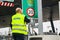 Worker in safety vest changing a sign at a turnpike toll gat