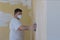 Worker sanding the drywall mud using sand trowel during renovation the house