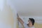 Worker sanding the drywall mud using sand trowel during renovation the house