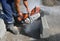 A worker saws a concrete curb with a circular saw.