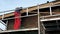 Worker on scaffolding installing new wooden planks on house roof eaves