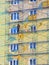 A worker on scaffolding warms the wall of a multi-storey building