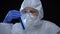 Worker of scientific lab holding test tube with biological hazard sign, harm