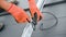 Worker securing cables by special tie while installing solar panels system on rooftop of house.