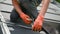 Worker securing cables by special tie while installing solar panels system on rooftop of house.