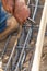 Worker Securing Steel Rebar Framing With Wire Plier Cutter Tool