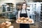 Worker selling pastries in bakery shop