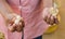 Worker shows in his hands a silkworm cocoon and its external caspule in a rural silk factory, Madagascar