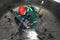 Worker sitting inside a steel industrial boiler during repair pr