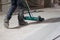 The worker is skillfully using a mechanical brush to clean and polish the surface of the floor, ensuring that it remains in top