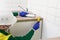 A worker smears the edges of the kitchen countertop with liquid glue using a rubber spatula to install the aluminum corner