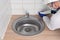 A worker smears silicone on the joint between the countertop and the ceramic tile using a special gun