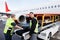 Worker Smiling While Colleague Unloading Luggage On Runway