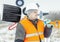 Worker with snow shovel near signal beacons in winter