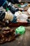 Worker sorts trash on conveyor belt at waste recycling plant