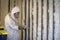 Worker spraying closed cell spray foam insulation on a home wall