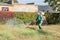 Worker sprays territory with insecticide for mosquitoes or pests or herbicides for weeds