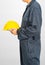 Worker standing in blue coverall holding hardhat