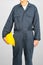 Worker standing in blue coverall holding hardhat