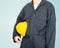Worker standing in blue coverall holding yellow hardhat