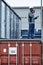 Worker standing on containers in shipping docks