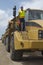 Worker Standing On Truck At Landfill Site