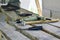 a worker stands and works on the old wooden scaffolding on which the tools lie