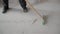 A worker sweeps white concrete dust from the floor. Garbage collection after repair work at home. A worker brushes the