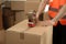 Worker taping cardboard box, closeup view