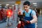 Worker testing laser level on tripod in tool store