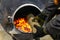 A worker throws firewood into an oven to heat a room