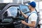 Worker tinting car window with foil