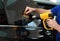 Worker tinting car window with heat gun in workshop, closeup