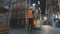 A worker transports a load on an electric hydraulic forklift. Large modern warehouse. Modern special equipment in stock