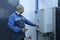 Worker turning switch on the control board panel of the electrolysis units set in the hall of the water pumping station