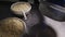 Worker turns raw cheese over metal table in workshop closeup