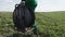 Worker in Uniform Carries Black Bobbin along Meadow