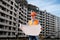 worker in uniform and a helmet holds in his hands a detailed plan on the construction site.