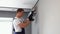 Worker in uniform installs air conditioner in the apartment. Construction, maintenance and repair concept