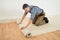 Worker unrolling carpet on floor