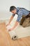 Worker unrolling carpet on floor