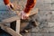 Worker up wooden rail with a with a screwdriver, on table in sawdust