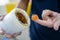 Worker use finger to scoop up lithium grease from white plastic can in the laboratory. Yellow transparance grease on the finger.