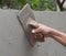 Worker use trowel plastering concrete at wall