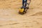 Worker in use vibratory plate compactor for compaction sand during path construction.