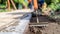 A worker uses a concrete edger to create a smooth and rounded edge adding both functionality and aesthetic appeal to the