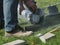 worker uses a stone cutter to cut the brick pavers