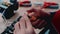 The worker uses tools to assemble the electrical circuit on the table.