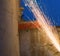 A worker using angle grinder in a house producing  sharp orange sparks