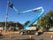 Worker using an articulated boom lift to affix surveillance camera on a pole